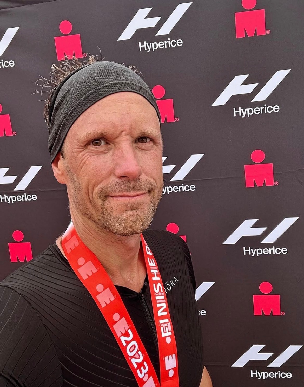 Menno Dellisse at an Ironman finish line, with his medal